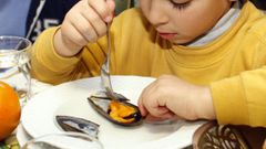 Imagen de archivo de un ni�o comiendo mejill�n en un centro escolar