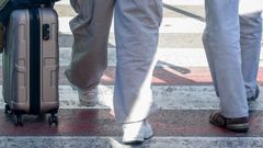 Un hombre con una maleta camino al aeropuerto.