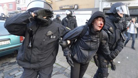 Policas antidisturbios escoltan a una manifestante herida. 