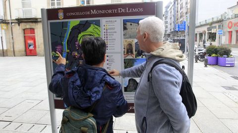 Turistas frente a un panel informativo a la entrada de la zona peatonal de Monforte