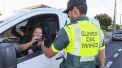 Los agentes realizando una prueba de alcoholemia a una conductora, que dio negativo.