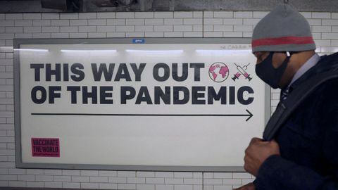 Un hombre con una mascarilla camina en el metro de Londres
