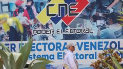 Un hombre camina ante un mural del Consejo Nacional Electoral (CNE) en Caracas