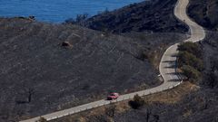 Un autom�vil circula por la carretera que discurre por la zona del incendio que, desde este viernes afect� al parque natural de Cap de Creus y que fue estabilizado este domingo.