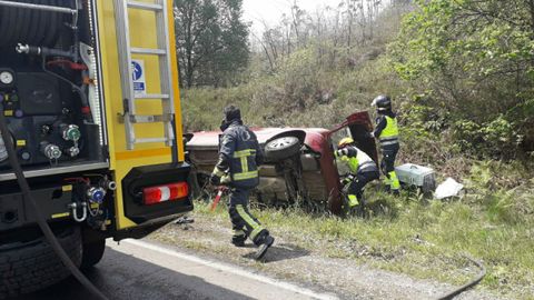 Bomberos de La Morgal con el coche accidentado en Siero