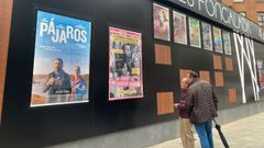 Una pareja de hombres observa las pel�culas de estreno del nuevo cine de Oviedo