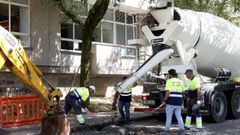 Los operarios contratados por la USC tapan baches en la calle Lope Gmez de Marzoa, frente a Matemticas