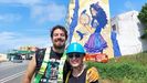 Cristian y Lidia, delante del mural de 20 metros de alto y unos 13 de ancho que han pintado en el edificio Santa Marta, a la entrada de Ortigueira desde Ferrol