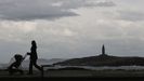 Una mujer camina por el paseo mar�timo de A Coru�a en una jornada lluviosa.