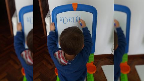 Adrin, que empez este ao el colegio, repasa letras y nmeros en su pizarra