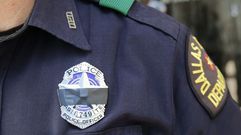 Un polic�a con una cinta negra indentificavia que participa en el rezo por las v�ctimas de la matanza en Dallas