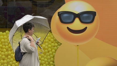 Una mujer se protege de la lluvia con un paraguas, en el recinto ferial de la Feria Internacional de Muestras de Asturias (FIDMA) en Gij�n. Asturias