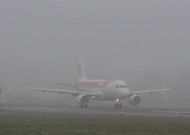 Un avin de Iberia, tomando tierra en la pista de Alvedro en un da con niebla. 