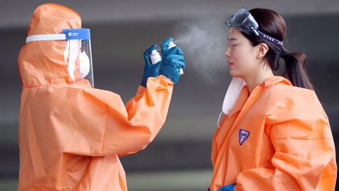 En Corea del Sur, un trabajador sanitario roc�a con un esprai a una compa�era durante un descanso