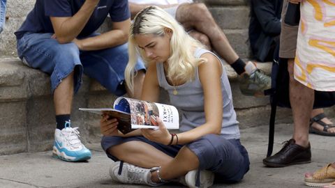 Turistas aprovechando para leer por las largas colas para acceder a la Catedral