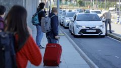 Viajeros esperando en la parada de taxis de Alvedro.