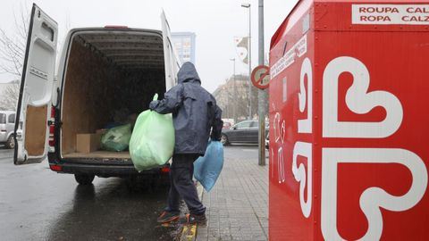 Manuel, recogiendo la ropa del contenedor situado en la plaza de O Infernio