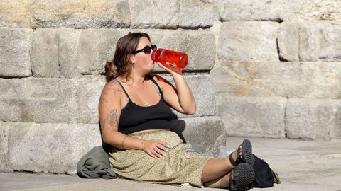 Una mujer se refresca en la plaza del Obradorio, en Santiago