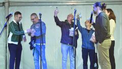 Bruno Lozano, presidente de la EGO, entrega la menina gaiteira del 50 aniversario al actual director, Rodrigo López, y a dos de los anteriores, César Muíños y Xavier Garrote (el fundador)