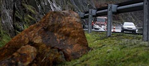 Una de las piedras desprendidas ayer por la ma�ana sobre la calzada, y al fondo, los bomberos.