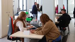 Funcionaria atentiendo a una usuaria en una oficina de empleo.