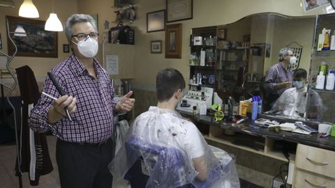 José María Barreiro atiende a un cliente en la Peluquería Pepe de Sigüeiro