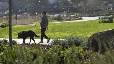 Una vecina camina por uno de los parques de Santa Cruz, en Oleiros