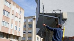 Un t�cnico cortando los cables sujetos a un edificio de la r�a �lamos y que daban servicio de telecomunicaciones a la r�a Sauces, en Oleiros.