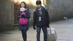 Tur�stas asi�ticos con maletas en una calle de Santiago