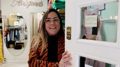 Sara Magari�os, responsable de la tienda pontevedresa Alma Gemela, mostrando el horario de su establecimiento, con apertura a las 11.00 horas.