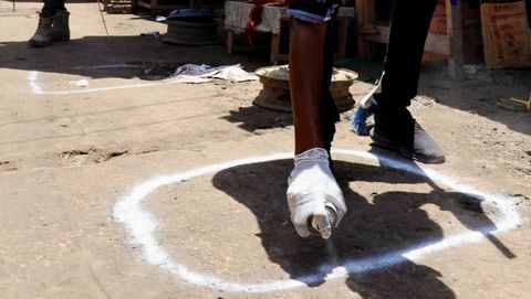Un trabajador sanitario pinta en el suelo de una localidad de Somalia zonas para mantener la distancia social