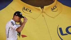 El británico Christopher Froome, líder general al final de la decimosexta etapa del Tour de Francia 2017, sube al podio para celebrar su maillot amarillo