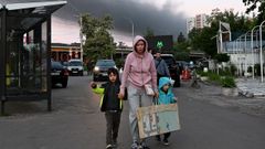 Una mujer regresa de un refugio junto a sus hijos, tras los ataques con misiles y drones rusos en Kiev