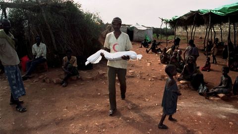 Un somal� lleva en brazos a un ni�o muerto para enterrarlo en un campo de refugiados de Baidoa, Somalia