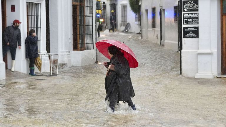 Una vecina de Grazalema (C�diz) caminaba ayer por una calle inundada debido a las intensas lluvias que se registran este mi�rcoles en la localidad gaditana