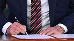 Firma de un documento, en imagen de archivo