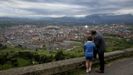 Un abuelo y su nieto miran Oviedo desde el Naranco