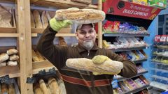 �scar, con algunos de los panes que vende en su local