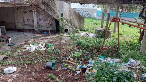 Exterior de una vivienda con desperdicios junto a la calle Vias de Babilonia