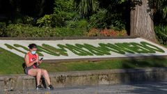 Una mujer descansa ante el mural de hierba que se renueva todos los d�as con la fecha en el campo San Francisco de Oviedo