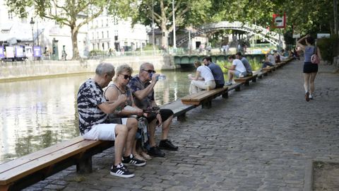Varias personas descansan del calor a orillas del Sena