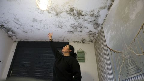 Elena Loureiro, en su dormitorio con el techo y las paredes cubiertos de moho.