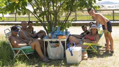Una familia se refugia del calor a la sombra de un �rbol en la playa de Carnota