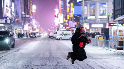 Una mujer salta en medio de una calle de Nueva York cortada por la nevada
