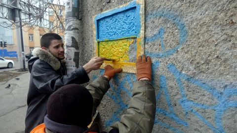 Funcionarios municipales pintando una bandera ucraniana en Odesa