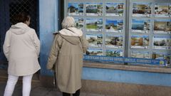 Dos mujeres mirando el escaparate de una inmobiliaria en A Corua