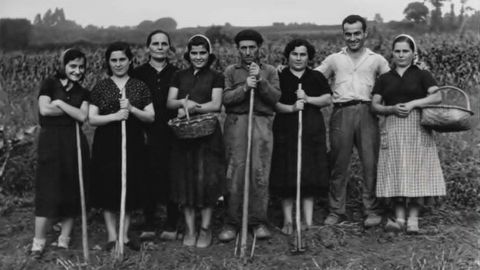 Mujeres con varas, aperos y alg�n hombre en el rural ferrolterrano.