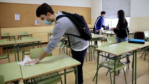 Alumnos desinfectan las mesas en el IES Ollos Grandes de Lugo