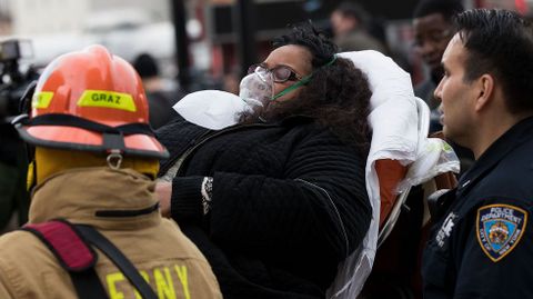 Miembros de la Polic�a y del cuerpo de bomberos transportan a una de las personas heridas.