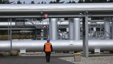 Un vigilante camina junto a unas tuber�as pertenecientes al gasoducto Nord Stream 2, en la localidad alemana de Lubmin